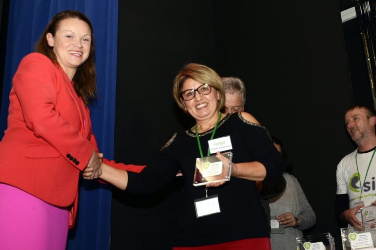 A female interpreter being presented with an award by Bella Sankey.