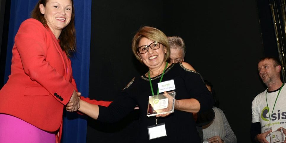 A female interpreter being presented with an award by Bella Sankey.