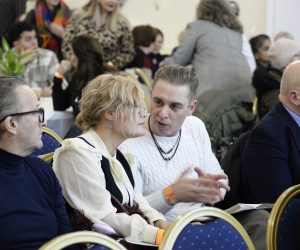 A group of people seated one is interpreting for the others.