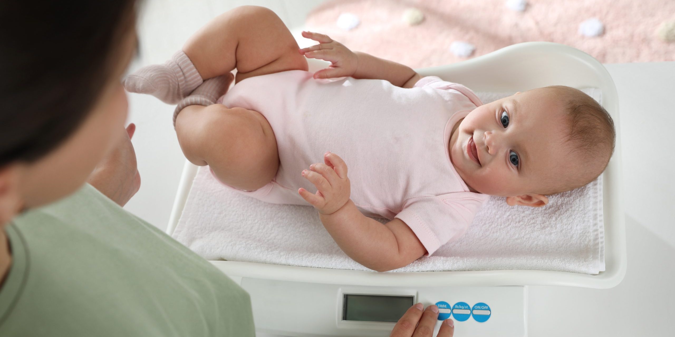 Young,Woman,Weighting,Her,Cute,Baby,At,Home,,Above,View.